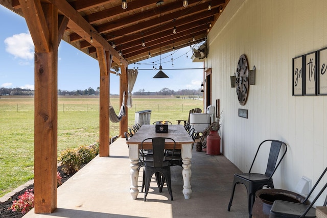 view of patio featuring outdoor dining area and a rural view