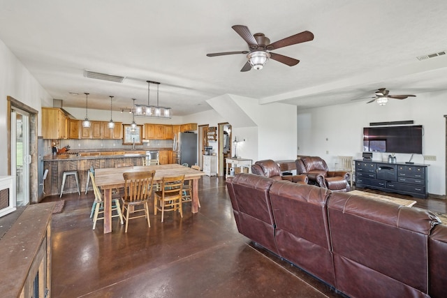 living room featuring visible vents, finished concrete floors, and a ceiling fan