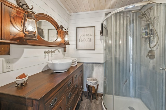 bathroom with wooden walls, a shower stall, wood ceiling, and vanity