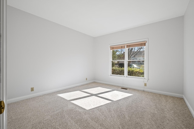 carpeted spare room with visible vents and baseboards