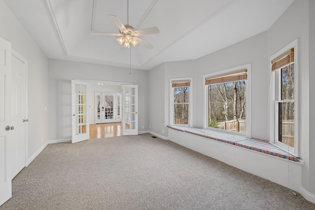 unfurnished room with a ceiling fan, baseboards, carpet floors, french doors, and a raised ceiling