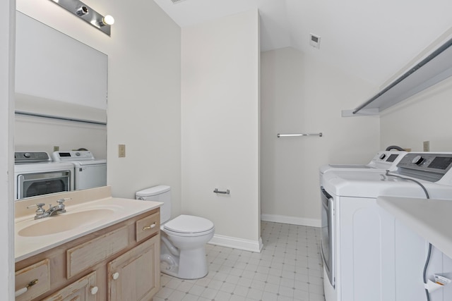 bathroom featuring vanity, baseboards, separate washer and dryer, tile patterned floors, and toilet
