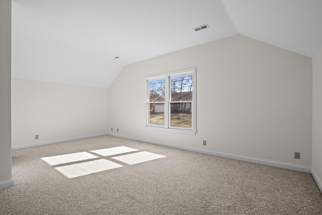 additional living space with visible vents, light colored carpet, and lofted ceiling