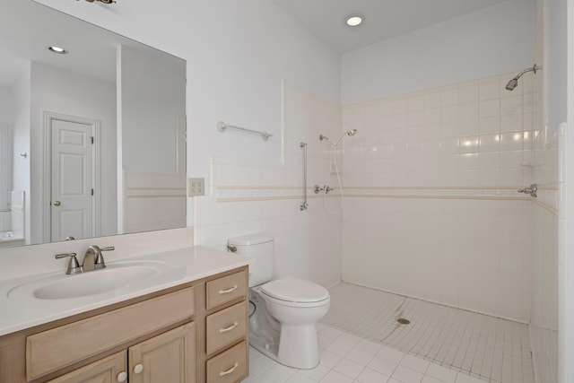 bathroom featuring vanity, tile walls, toilet, and a tile shower