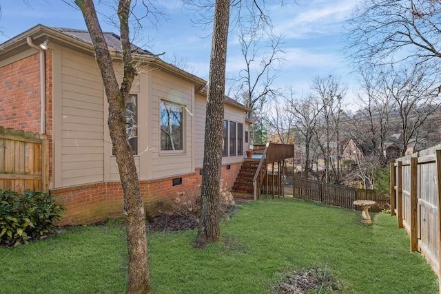 view of yard with stairs, a deck, a fenced backyard, and a sunroom
