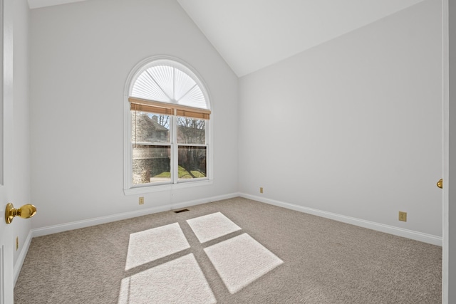 carpeted empty room with visible vents, baseboards, and vaulted ceiling