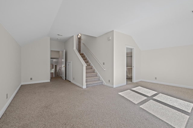 bonus room with baseboards, light carpet, stairs, and vaulted ceiling