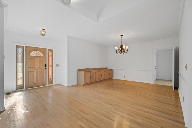 foyer entrance with visible vents, crown molding, baseboards, light wood-style flooring, and a notable chandelier