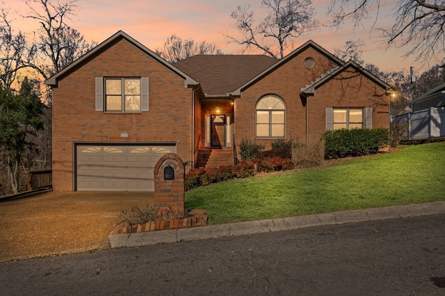 view of front of house with a yard, brick siding, concrete driveway, and an attached garage