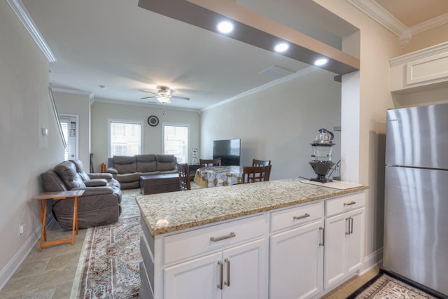 105 David Bolin Dr, La Vergne, TN 37086 - kitchen with light stone counters, a ceiling fan, freestanding refrigerator, ornamental molding, and white cabinetry