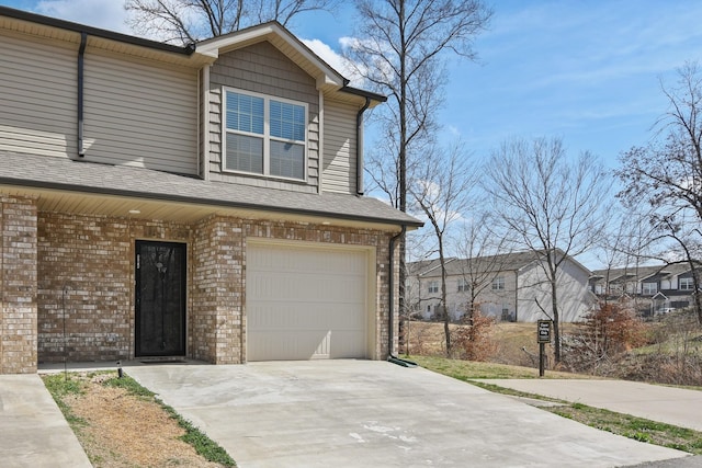 view of front of house featuring an attached garage, brick siding, and driveway