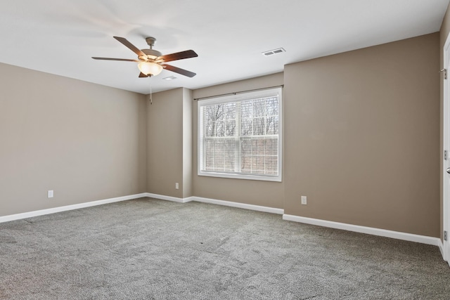 empty room with visible vents, baseboards, a ceiling fan, and carpet floors