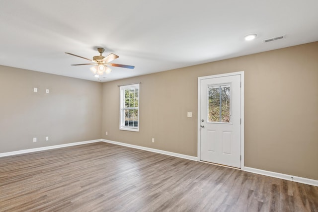 empty room with baseboards, wood finished floors, and ceiling fan