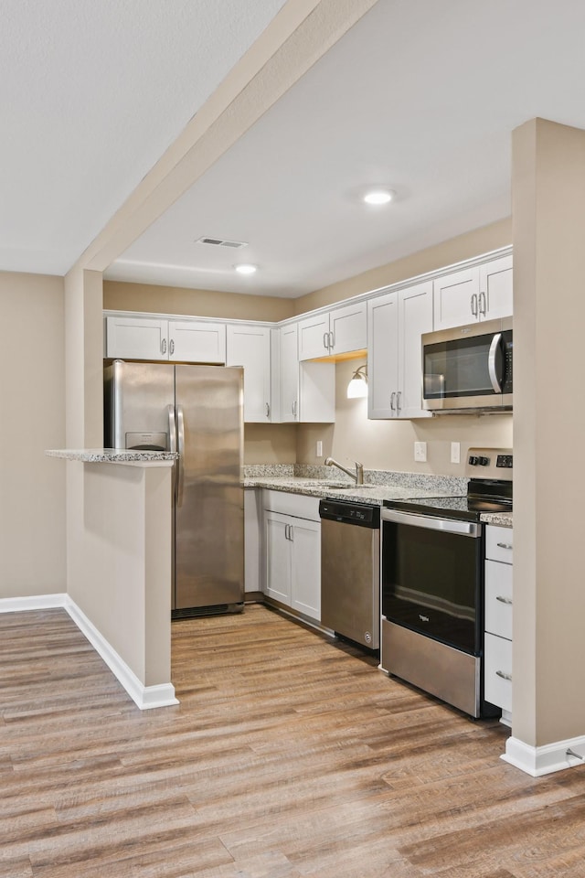 kitchen with visible vents, light wood-style flooring, appliances with stainless steel finishes, and white cabinetry