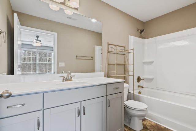 bathroom with visible vents, ceiling fan, toilet, vanity, and  shower combination