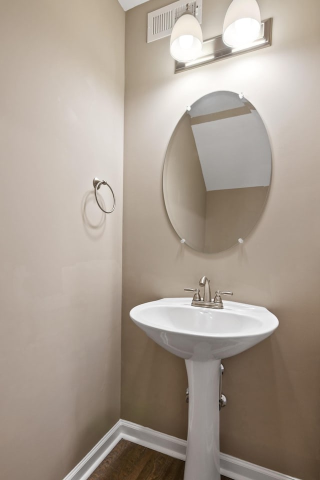 bathroom featuring visible vents, baseboards, and wood finished floors