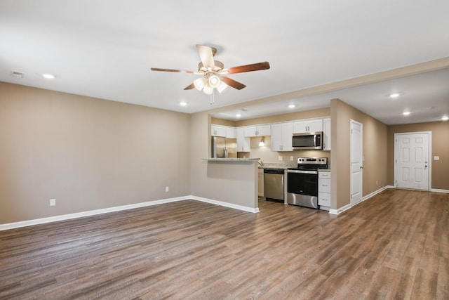 kitchen featuring a ceiling fan, baseboards, dark wood-style flooring, stainless steel appliances, and white cabinetry