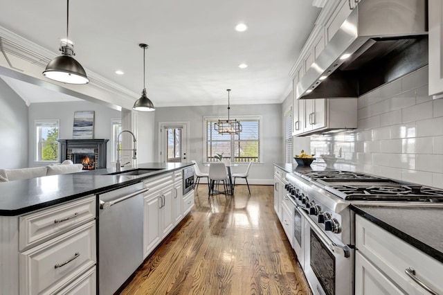 2821 Brentwood Knoll Ct, Nashville, TN 37211 - kitchen with stainless steel appliances, wall chimney range hood, a sink, dark countertops, and crown molding
