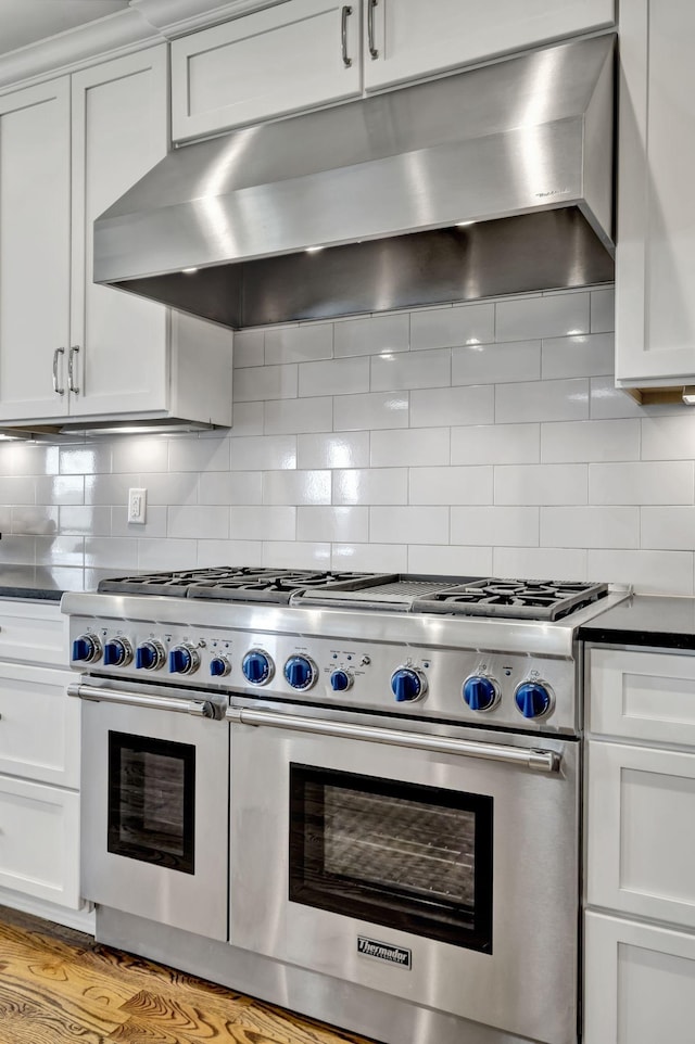 2821 Brentwood Knoll Ct, Nashville, TN 37211 - kitchen with under cabinet range hood, range with two ovens, dark countertops, white cabinets, and backsplash
