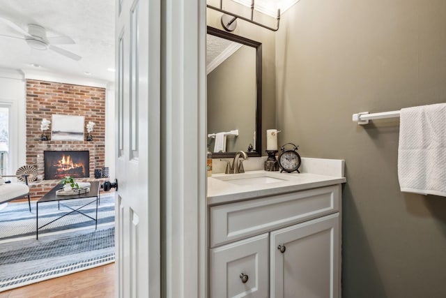 102 Foxborough Sq W, Brentwood, TN 37027 - bathroom with crown molding, a brick fireplace, ceiling fan, wood finished floors, and vanity