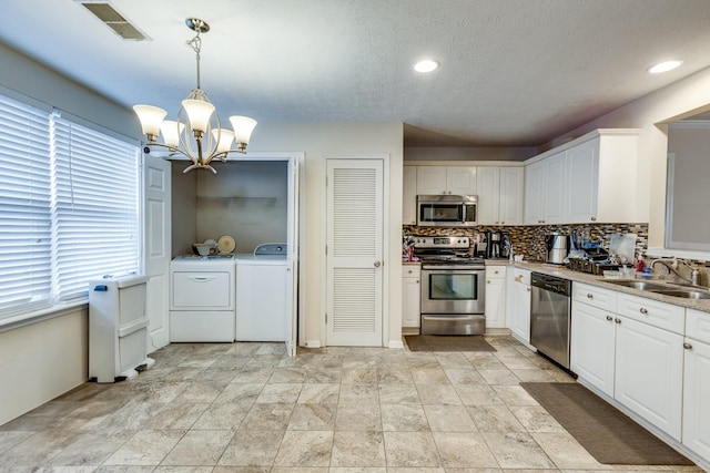 2962 Baby Ruth Ln Unit 8, Antioch, TN 37013 - kitchen featuring washing machine and clothes dryer, tasteful backsplash, a notable chandelier, stainless steel appliances, and a sink