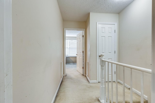 2962 Baby Ruth Ln Unit 8, Antioch, TN 37013 - hallway featuring baseboards, light carpet, a textured ceiling, and an upstairs landing
