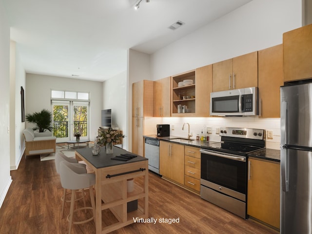 kitchen featuring a sink, dark countertops, open shelves, and stainless steel appliances