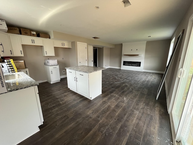 176 Cardinal Crk, Clarksville, TN 37040 - kitchen featuring dark wood-style flooring, a center island, stone countertops, and white cabinets