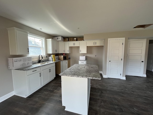 176 Cardinal Crk, Clarksville, TN 37040 - kitchen featuring a sink, light stone counters, a center island, white cabinetry, and baseboards