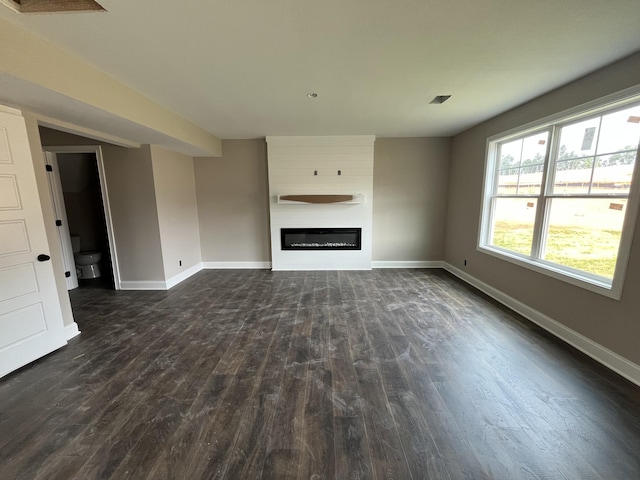 176 Cardinal Crk, Clarksville, TN 37040 - unfurnished living room featuring dark wood-style flooring, baseboards, and a glass covered fireplace