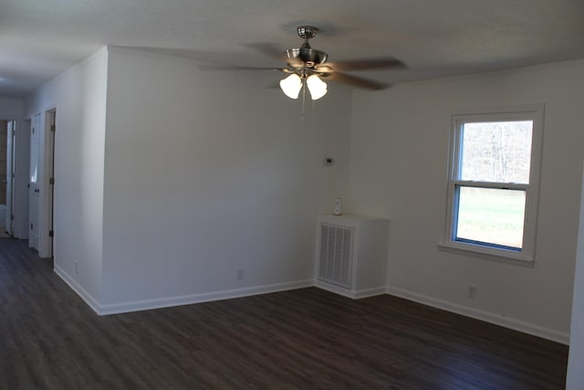 spare room featuring visible vents, dark wood-style floors, crown molding, baseboards, and ceiling fan