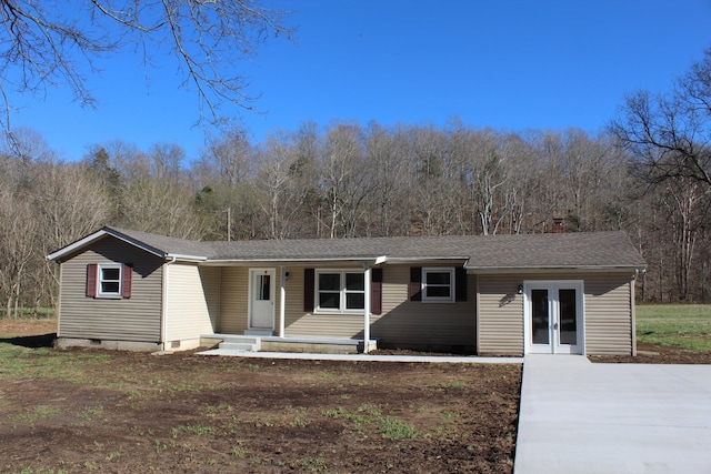 view of front of house with french doors and roof with shingles