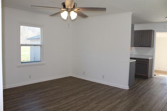 interior space featuring baseboards, dark wood-type flooring, ceiling fan, and ornamental molding