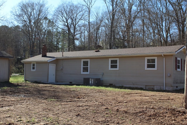 rear view of house with crawl space, central air condition unit, and a chimney