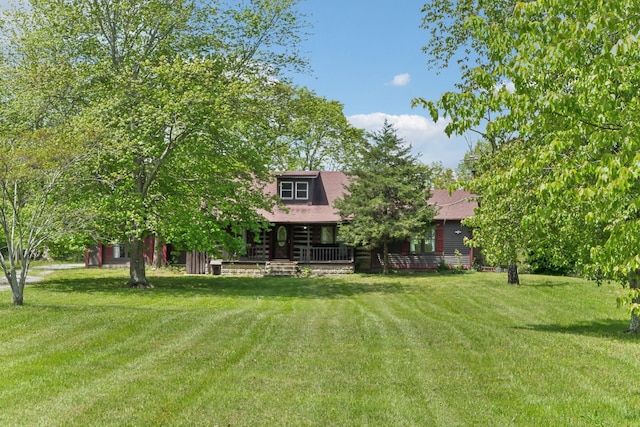 exterior space with a yard, roof with shingles, and covered porch