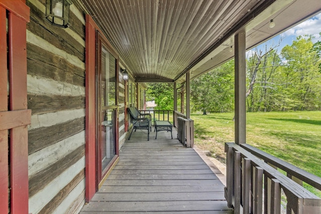 wooden terrace featuring a yard and covered porch