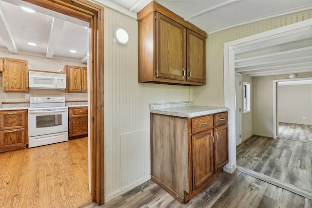 kitchen featuring light countertops, light wood-style flooring, white appliances, and brown cabinetry