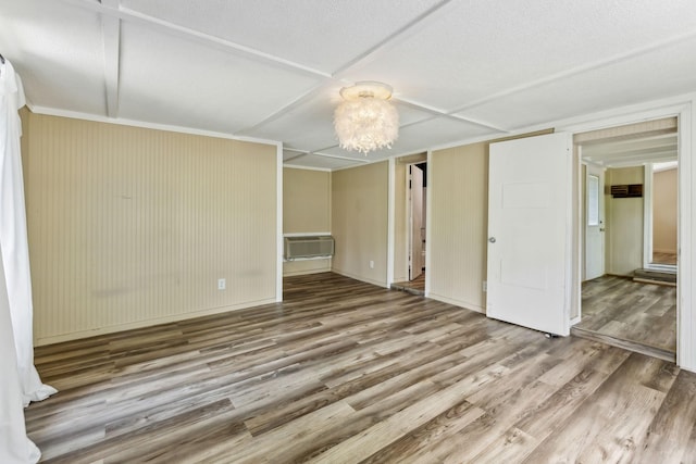 interior space with a wall mounted AC, baseboards, wood finished floors, and an inviting chandelier