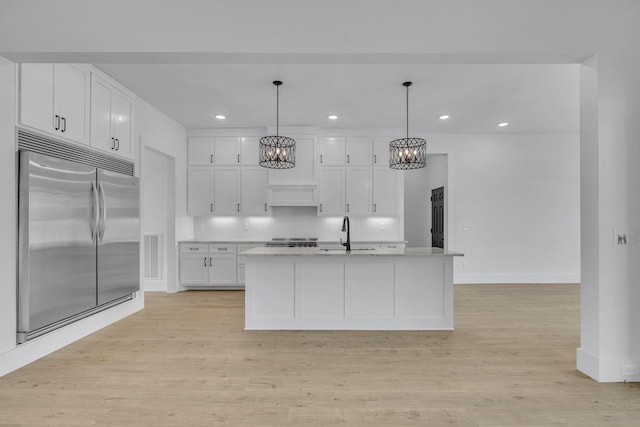 184 Emma Ln, Hohenwald, TN 38462 - kitchen with light wood finished floors, stainless steel built in refrigerator, a notable chandelier, white cabinetry, and a sink
