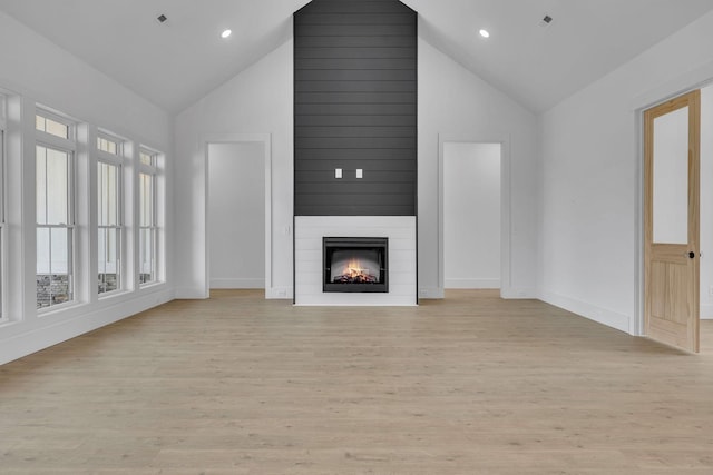 184 Emma Ln, Hohenwald, TN 38462 - unfurnished living room with a large fireplace, light wood-style floors, baseboards, and high vaulted ceiling
