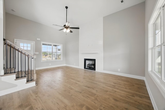 151 Cardinal Crk, Clarksville, TN 37040 - unfurnished living room with healthy amount of natural light, wood finished floors, stairway, a large fireplace, and a high ceiling