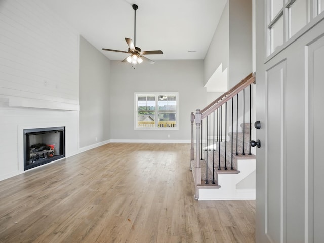 151 Cardinal Crk, Clarksville, TN 37040 - unfurnished living room with ceiling fan, light wood-style flooring, a large fireplace, stairway, and baseboards
