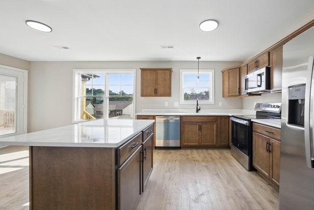 151 Cardinal Crk, Clarksville, TN 37040 - kitchen with appliances with stainless steel finishes, light wood-style floors, light countertops, a kitchen island, and a sink