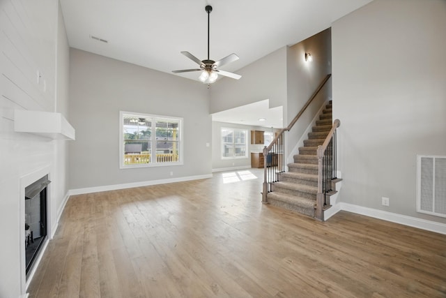 151 Cardinal Crk, Clarksville, TN 37040 - unfurnished living room with stairway, light wood-style flooring, a ceiling fan, a fireplace, and baseboards