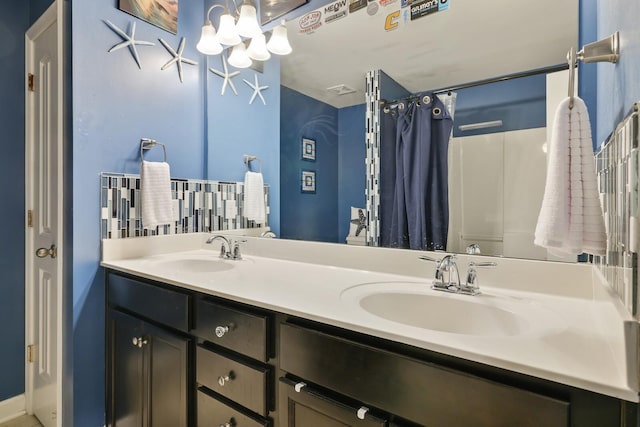 full bathroom featuring double vanity, a notable chandelier, curtained shower, and a sink