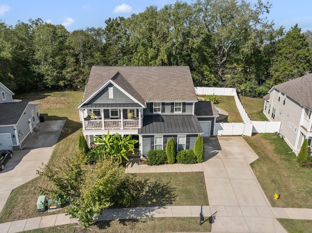 view of front of home with driveway, a gate, fence, roof with shingles, and a front yard