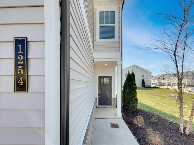 property entrance with a lawn