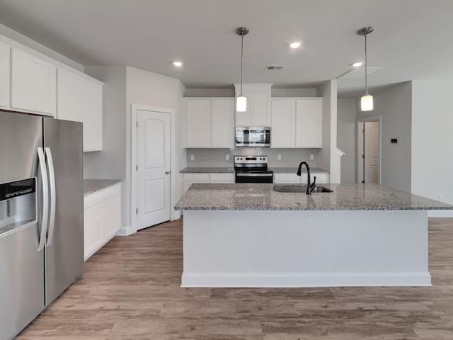 kitchen featuring light wood-style flooring, appliances with stainless steel finishes, white cabinets, and a sink