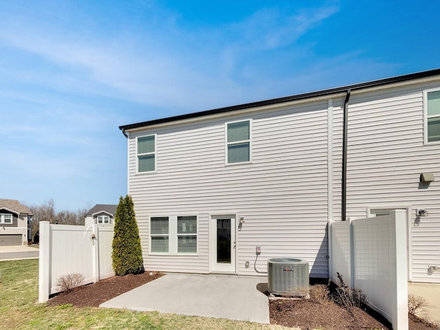 rear view of property featuring a patio, central AC, and fence