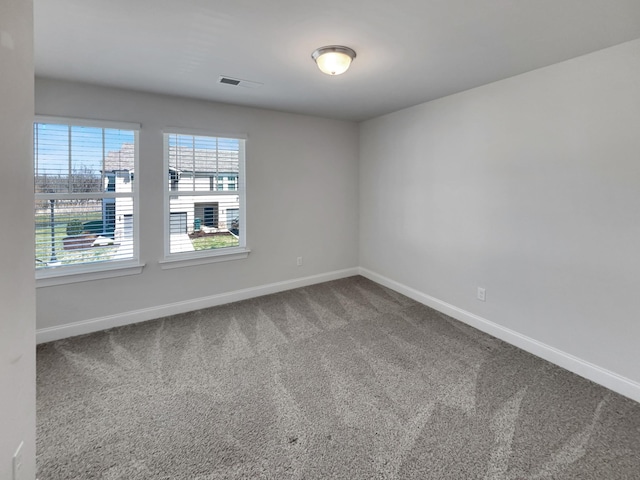 spare room featuring visible vents, baseboards, and carpet